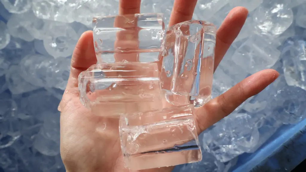 Clear hollow tube ice cubes held in a human hand